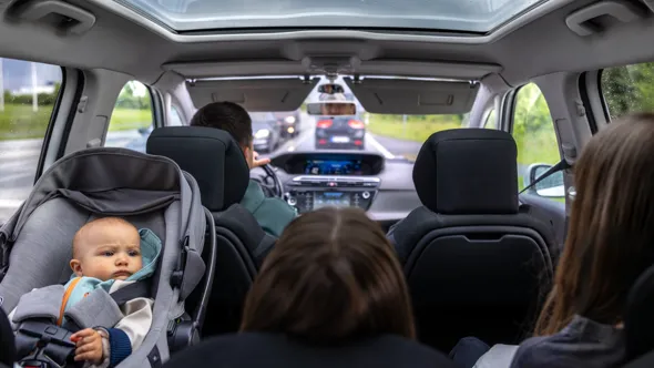 A family sitting in the back of a car.