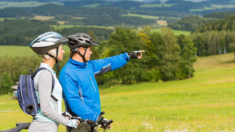 Ett par cyklister som blickar ut över ett landskap.