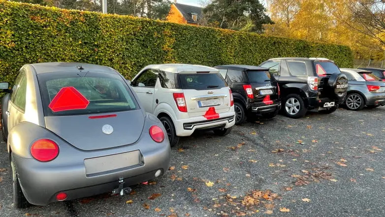 A-traktorer och mopedbilar på en parkering.