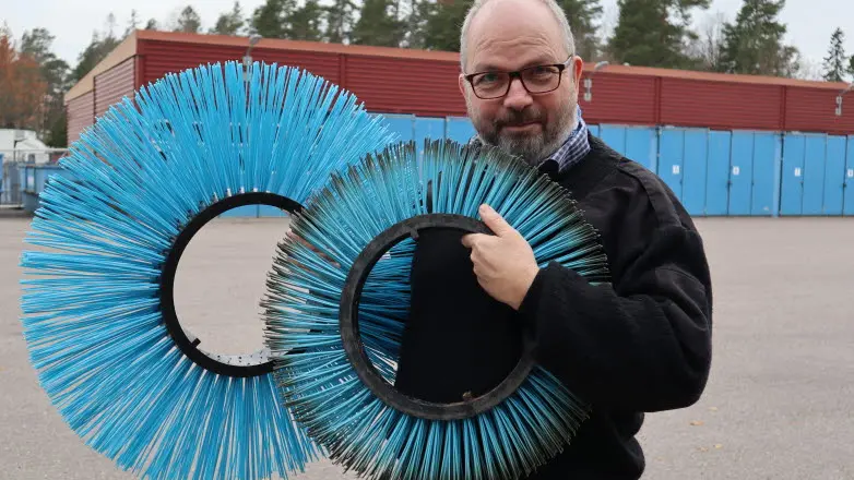 Man håller upp plastborstar.