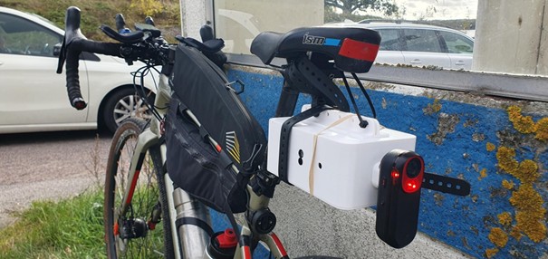 Bild på TrafficLogger som sitter monterad bakom och under cykelsadeln tillsammans med annan utrustning i mitten på cykelramen.