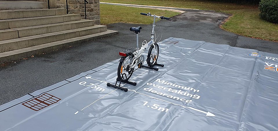 Educational set-up with a bicycle on a surface with measures for a safe pass.