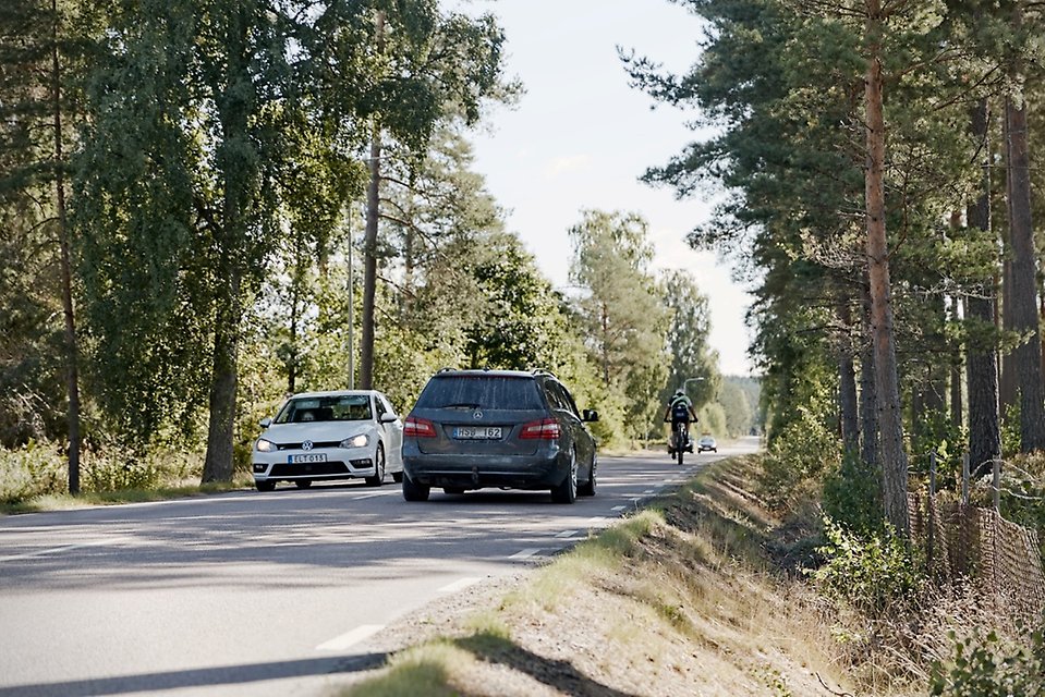 Rural road with meeting cars and one bicycle to overtake.